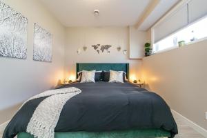 a bedroom with a large bed with a green headboard at Executive Home - Long Stays Welcome - Garage Parking - Free WiFi & Netflix in Edmonton