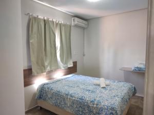 Un dormitorio con una cama con una toalla. en Apart. japaratinga, en Japaratinga