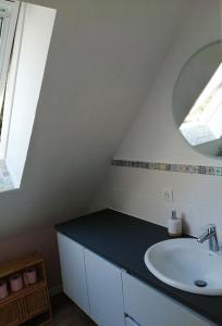W łazience znajduje się umywalka i lustro. w obiekcie Duplex du Bois d'Amour w mieście Quimper