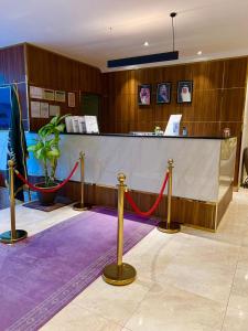 a waiting room with a red rope and a counter at Amaken Aparthotel in Al Ahsa