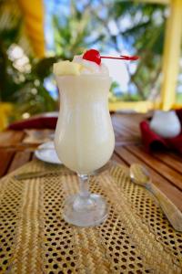 a drink in a glass with a cherry on a table at Stella Maris Resort Club in Stella Maris