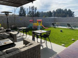 patio con mesa, sillas y parque infantil en Hotel Parada Linares en Linares