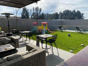 a patio with a table and chairs and a playground at Hotel Parada Linares in Linares