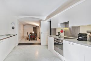 uma cozinha com armários brancos e uma sala de jantar em Garibaldi Glamorous Apartment by Wonderful Italy em Gênova