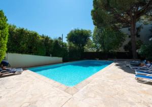 uma piscina com duas espreguiçadeiras num quintal em Cannes bel appartement familial avec piscine em Cannes