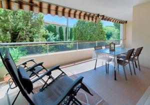 uma sala de jantar com mesa e cadeiras e uma grande janela em Cannes bel appartement familial avec piscine em Cannes