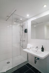 baño blanco con ducha y lavamanos en Pentahotel Bremen en Bremen