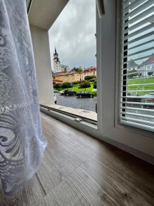 une fenêtre ouverte avec vue sur la rivière dans l'établissement Apartmán Pod fontánou, à Kremnica