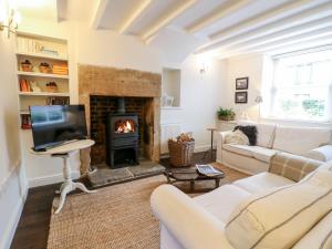 a living room with a fireplace and a tv at 16 Long Row in Belper