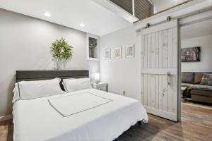 a bedroom with a white bed and a sliding door at Whiskey on the River in Petal