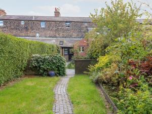 a garden with a brick building in the background at 16 Long Row in Belper