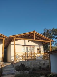 a house with a wooden pergola on it at Chalés e Suítes Campos de São João in Palmeiras