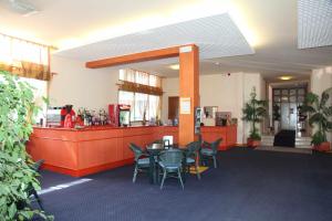 a restaurant with a table and chairs and a counter at Hotel Bettina in Lido di Jesolo