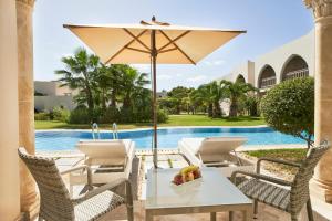 特里法的住宿－TUI BLUE Palm Beach Palace Djerba - Adult Only，庭院配有桌椅和遮阳伞。
