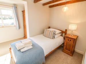 a small bedroom with a bed and a lamp at Orchard Cottage in Ashbourne