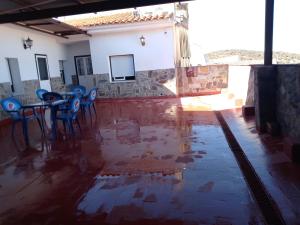 Habitación con mesa, sillas y agua en el suelo en Hostal 2 estrellas -Restaurante Las Tres Encinas, en Cabeza la Vaca