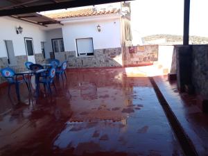 um quarto com uma mesa e cadeiras e água no chão em Hostal 2 estrellas -Restaurante Las Tres Encinas em Cabeza la Vaca