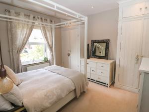 a bedroom with a bed and a window and a dresser at Olive Tree Cottage in Holmfirth