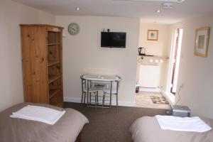 a room with two beds and a table and a tv at Twin Bays in Hedon