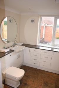 a bathroom with a toilet and a sink and a mirror at Twin Bays in Hedon