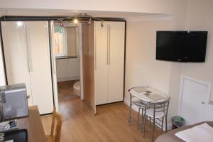 a living room with a table and a television on the wall at Twin Bays in Hedon