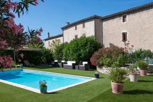 a swimming pool in the yard of a house at Hôtel Restaurant Le Clos Charmant in Vallon-Pont-dʼArc