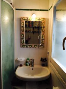 ein Badezimmer mit Waschbecken und Spiegel in der Unterkunft TL Palazzo Fantuzzi in Bologna