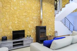 a living room with a fireplace and a stone wall at A Casa da Inês in São Vicente Ferreira