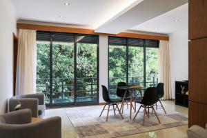 a living room with a table and chairs and large windows at A Casa da Inês in São Vicente Ferreira