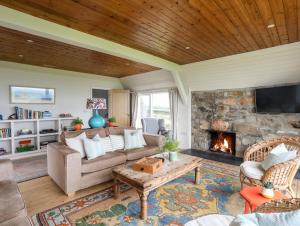 a living room with a couch and a fireplace at Bryn Odol Bach in Pwllheli