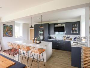 a kitchen with dark blue cabinets and a white island at Bryn Odol Bach in Pwllheli