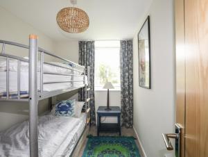 a bedroom with two bunk beds and a window at Bryn Odol Bach in Pwllheli