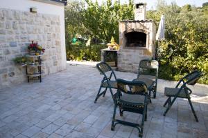 patio z 4 krzesłami i kamiennym kominkiem w obiekcie La casetta di Eve Casa Vacanze w mieście Guardialfiera