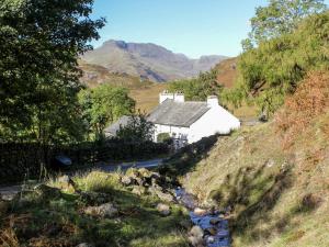 un cottage sul fianco di una collina con un ruscello di Windermere a Kendal