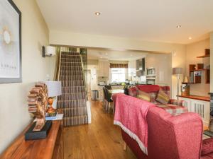 a living room with two couches and a kitchen at Scale Force in Keswick