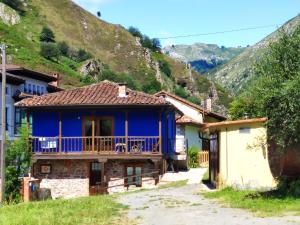 ein blaues Haus mit einem Balkon auf einem Berg in der Unterkunft Apartamento Aguas del Sella in Precendi