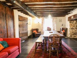 a living room with a table and a red couch at Gwengraig in Dolgellau