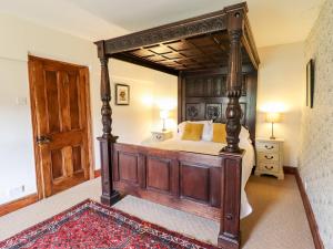 a bedroom with a large wooden bed with a wooden frame at Gwengraig in Dolgellau