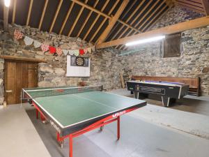 a ping pong table in a room with a piano at Gwengraig in Dolgellau