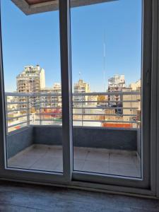 einen Blick auf die Stadt aus einem offenen Fenster in der Unterkunft Corazón de Flores in Buenos Aires