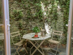 een tafel en stoelen op een patio met een bakstenen muur bij Lily Pad in Okehampton