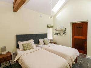 a bedroom with two beds and a window at Nythfa - 3 Plough & Harrow in Cowbridge