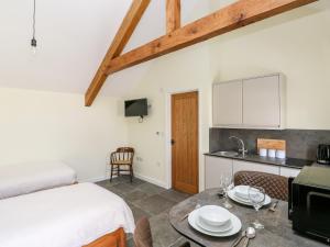 a room with a bed and a kitchen with a table at Trefechan - 4 Plough & Harrow in Cowbridge
