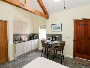 a kitchen with a table and chairs in a room at Trefechan - 4 Plough & Harrow in Cowbridge