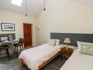 a bedroom with two beds and a table and a desk at Trefechan - 4 Plough & Harrow in Cowbridge