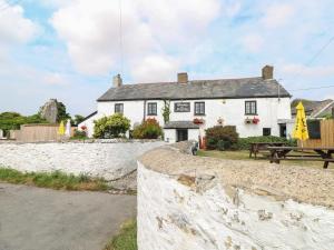 a white house with a picnic table in front of it at Llety Cariad - 2 Plough & Harrow in Cowbridge