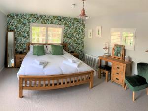 a bedroom with a bed and a desk and a chair at Ferryman`s Cottage at The Beetle & Wedge in Moulsford