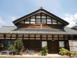 a building with a roof with a bicycle in front of it at 駅前宿舎 禪 shared house zen in Eiheiji