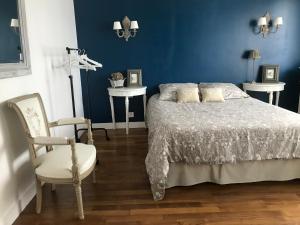 ein blaues Schlafzimmer mit einem Bett und einem Stuhl in der Unterkunft Jolie Chambre proche Centre Ville de Rennes in Rennes