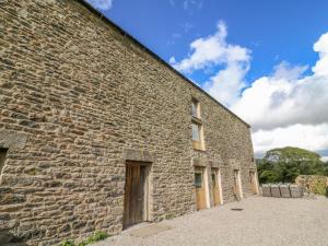 a brick building with a door on the side of it at Hollowgill Barn in Sedbergh